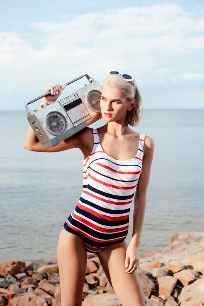 belle femme blonde en maillot de bain vintage posant avec magnétophone
 - Photo, image