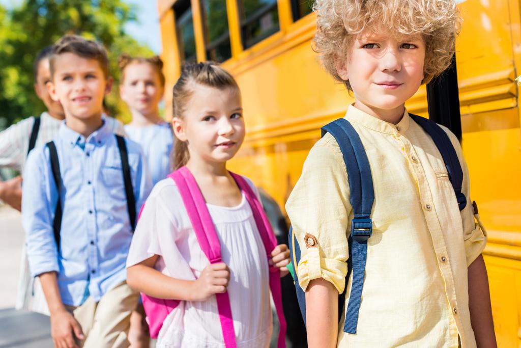 Skupina rozkošný spolužáci poblíž školní autobus - Fotografie, Obrázek