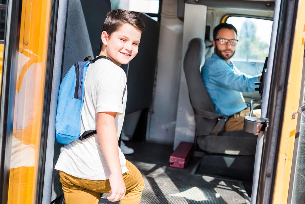 красивый водитель школьного автобуса и школьник смотрят в камеру
 - Фото, изображение