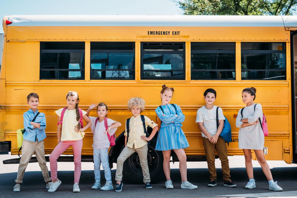 学校のバスの前でポーズかわいい小学生のグループ ロイヤリティフリー写真 画像素材