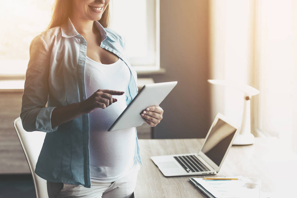 Νέοι ευτυχισμένη γυναίκα έγκυος χρησιμοποιώντας ψηφιακό Tablet. - Φωτογραφία, εικόνα