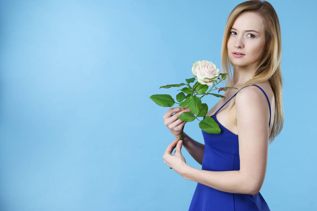白を保持している魅力的な金髪の若い女性はバラの花。バレンタインと女性の日、ギフトの概念. - 写真・画像