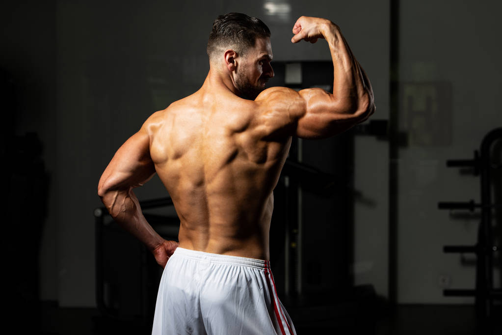Portret młodego sprawnego fizycznie mężczyzny Pokazywanie dobrze wyszkolonego ciała - Muscular Athletic Bodybuilder Fitness Model pozowanie po ćwiczeniach - Zdjęcie, obraz