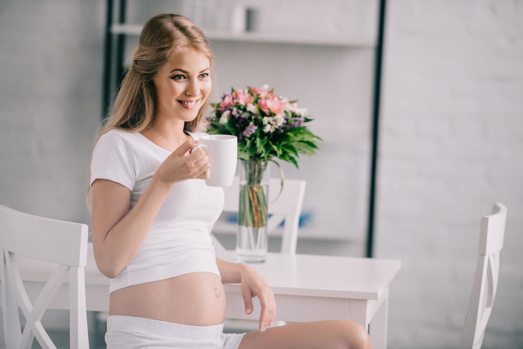 家でお茶を一杯で幸せな妊娠中の女性の肖像画 - 写真・画像