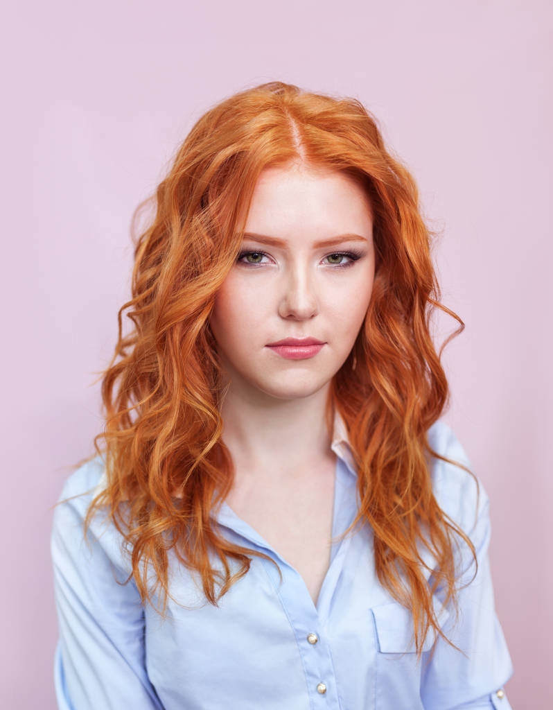 Portrait de belle fille aux cheveux roux sur fond rose
. - Photo, image