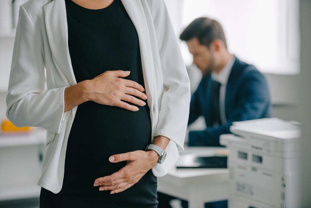Teilbild einer schwangeren Geschäftsfrau und Kollegin am Arbeitsplatz im Büro - Foto, Bild
