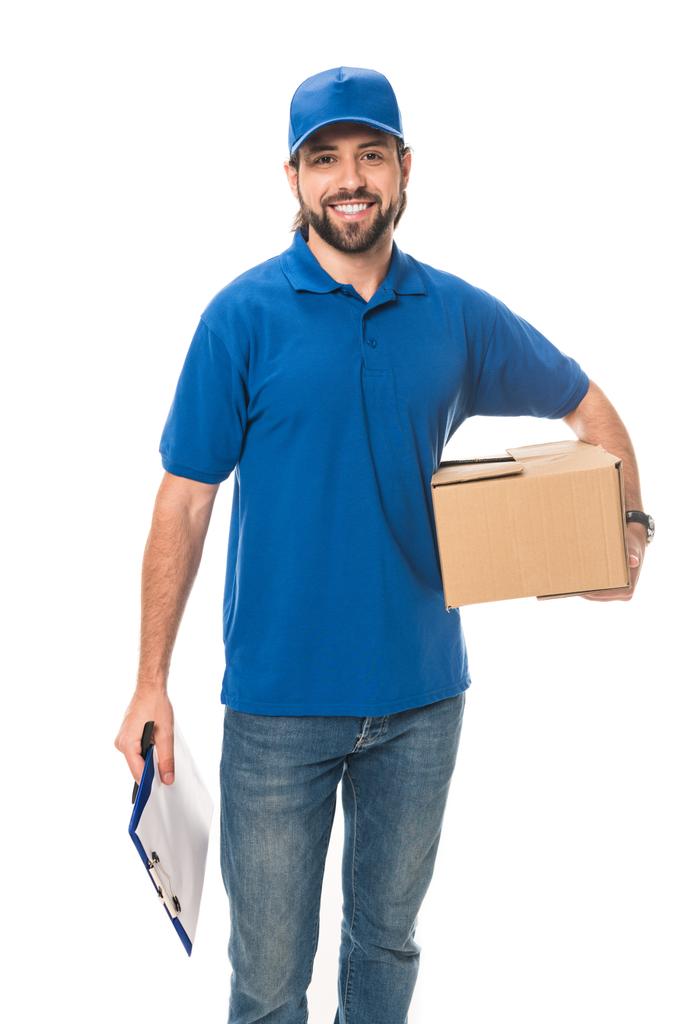 sonriente joven repartidor hombre sosteniendo caja de cartón y portapapeles en blanco aislado en blanco
  - Foto, Imagen