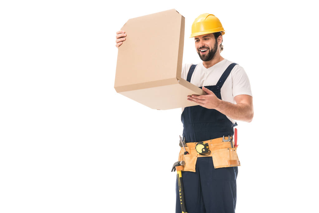 Happy dělník v tvrdé klobouk a nástroj pásu otevření krabice od pizzy izolované na bílém - Fotografie, Obrázek