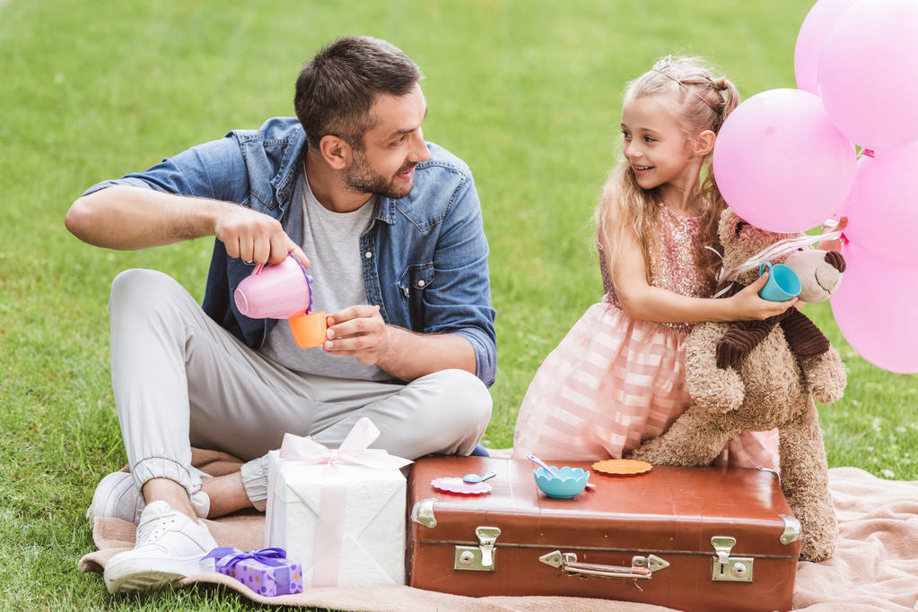 Vater und Tochter spielen Teeparty auf dem Rasen - Foto, Bild