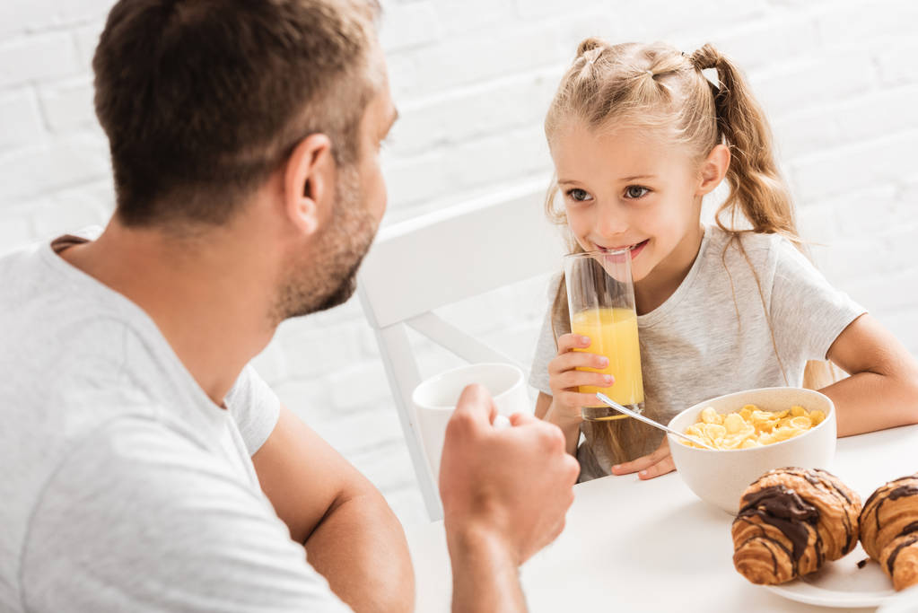 otec a dcera snídat a pohledu na sebe - Fotografie, Obrázek