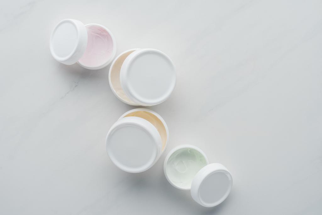 vue de dessus des bouteilles ouvertes de crème sur la surface blanche, concept de beauté
 - Photo, image