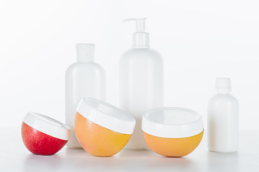 красные, оранжевые и белые бутылки крема на белой поверхности, концепция красоты
 - Фото, изображение