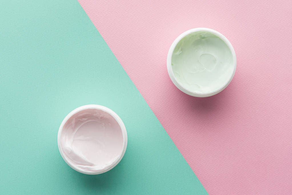 felülnézet üveg tejszín, rózsaszín és zöld felület, szépség-koncepció - Fotó, kép