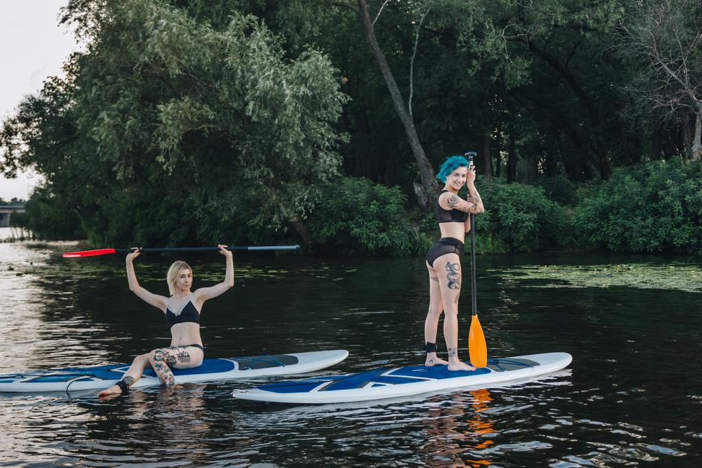 sportos női pihentető lapát táblák együtt a folyó - Fotó, kép