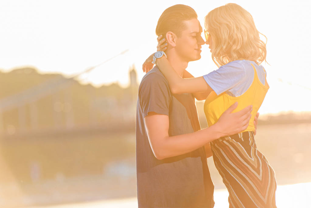 vue latérale du jeune couple va embrasser sur la plage de la rivière pendant le coucher du soleil
 - Photo, image