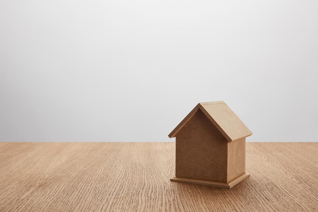 close-up view of small house model on wooden table on grey, insurance concept - Photo, Image