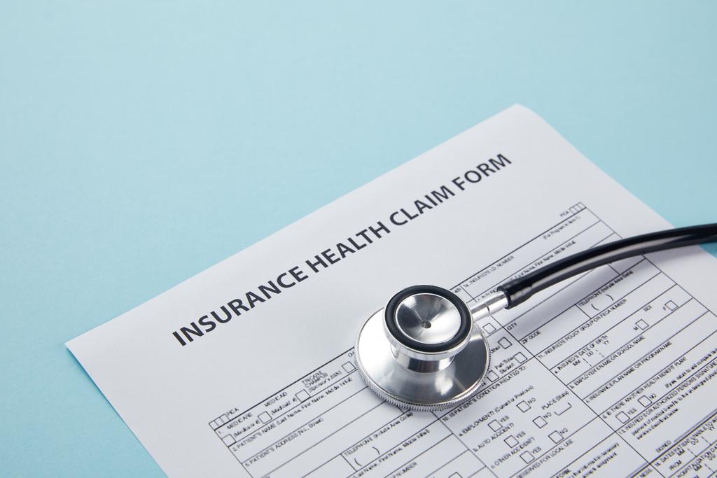 close-up view of insurance health claim form and stethoscope isolated on blue - Photo, Image