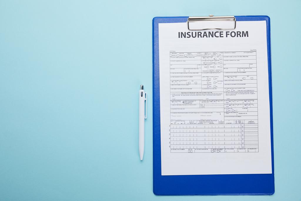 vue du dessus du formulaire d'assurance sur presse-papiers et stylo isolés sur bleu
  - Photo, image