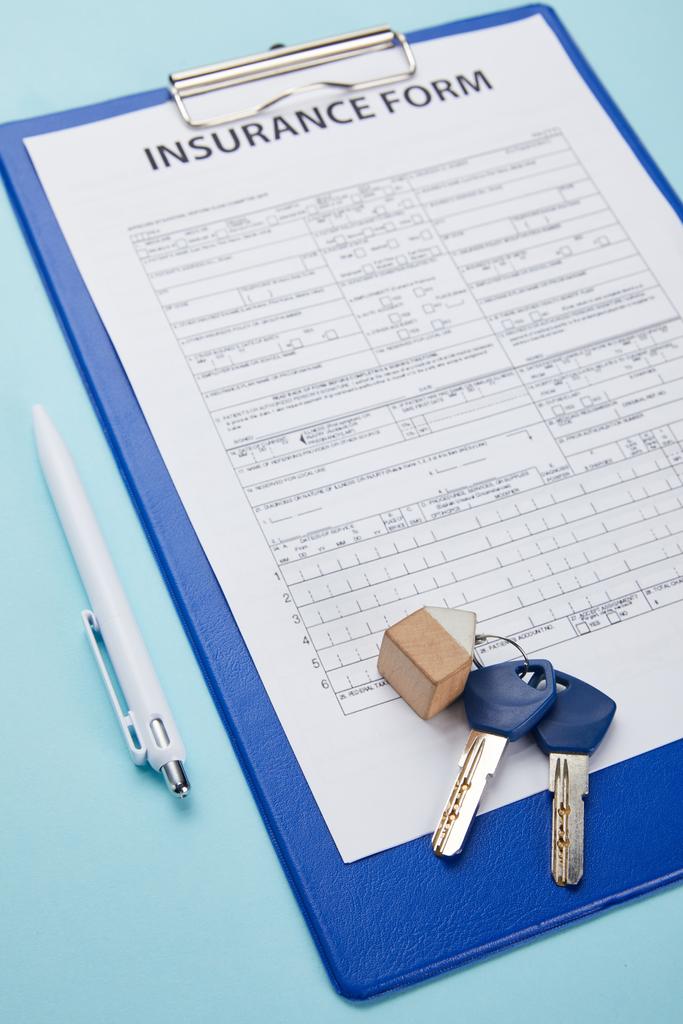 close-up view of insurance form, pen and keys isolated on blue  - Photo, Image