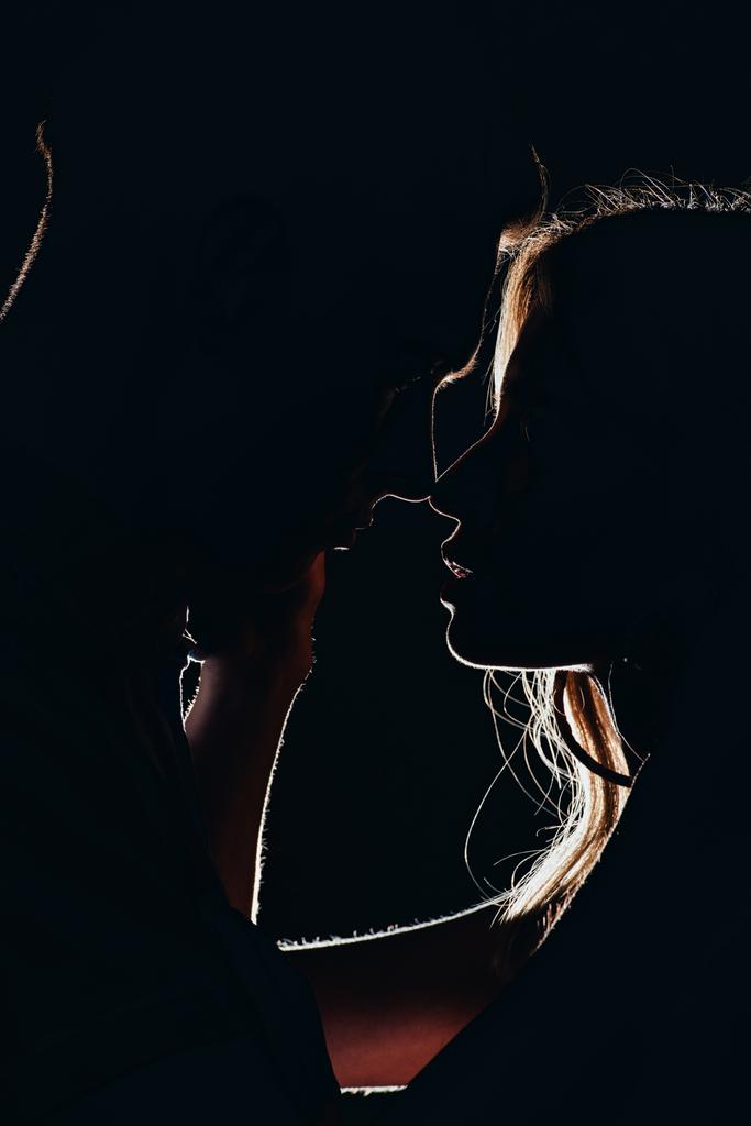 siluetit nuoren tarjouksen pari aikoo suudella pimeässä
 - Valokuva, kuva