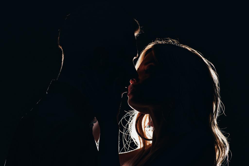 σιλουέτες των αισθησιακό ετεροφυλόφιλο ζευγάρι φιλί στο σκοτάδι - Φωτογραφία, εικόνα