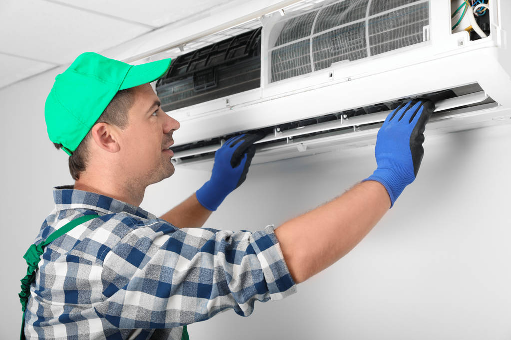 Técnico masculino instalando aire acondicionado en interiores
 - Foto, Imagen
