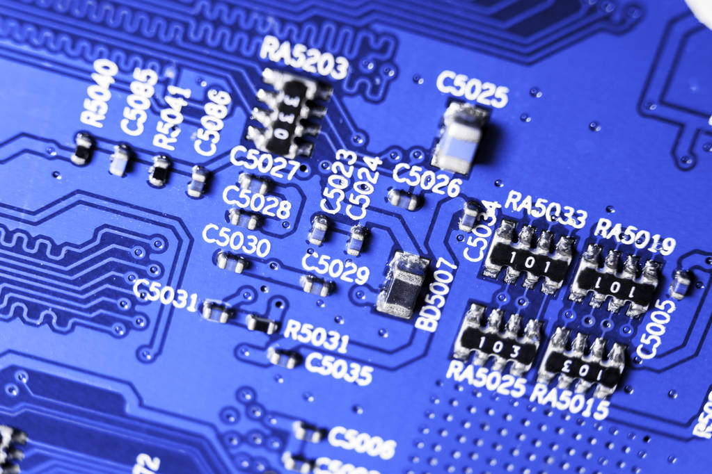 Makro snímek Circuitboard s odpory mikročipy a elektronických součástek. Počítačová technologie hardwaru. Integrované komunikační procesor v modrých tónech. Polovodič. Closeup PCB. - Fotografie, Obrázek