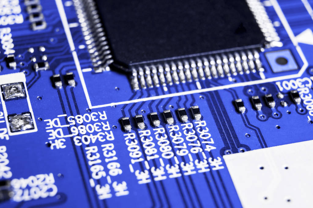 Makroaufnahme einer Platine mit Widerständen, Mikrochips und elektronischen Bauteilen. Computerhardwaretechnologie. integrierter Kommunikationsprozessor in Blautönen. Halbleiter. Leiterplatte. Nahaufnahme - Foto, Bild