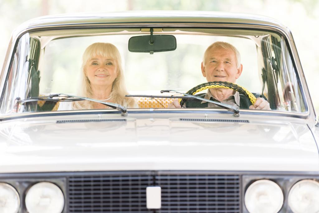 front view of senior man and woman in beige car - Photo, Image