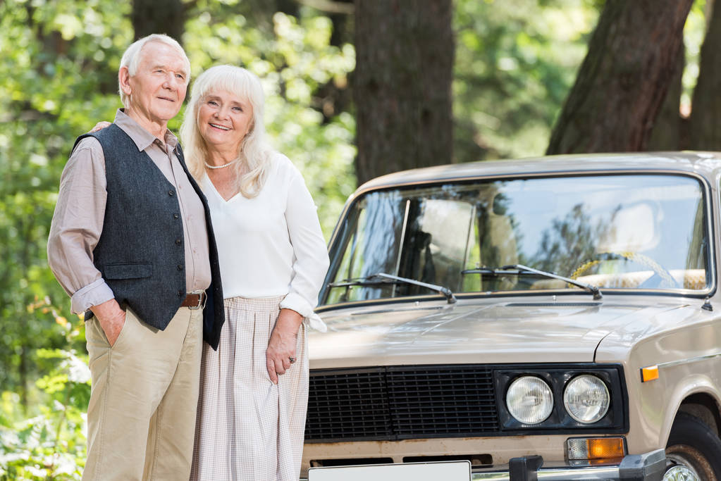 Senior férfi és a nő közelében bézs autó  - Fotó, kép