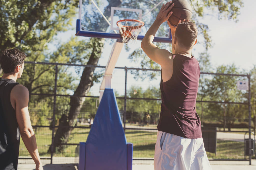 Jonge blanke man opleiding basketbal bij buiten Hof. - Foto, afbeelding