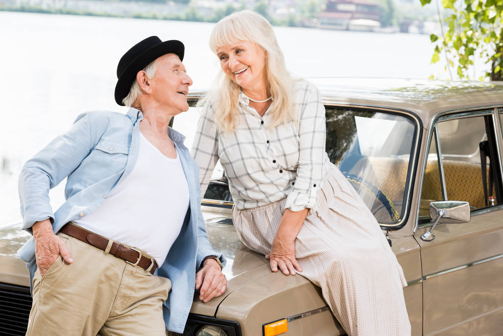 stylish senior man near woman sitting on beige car - Photo, Image