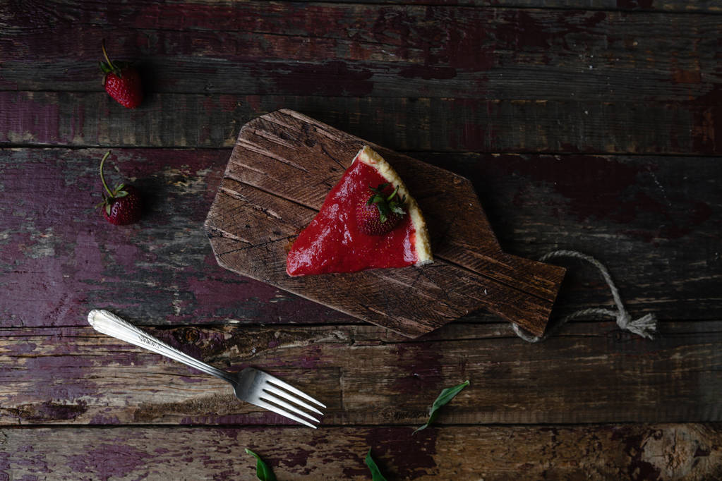 top view of piece of strawberry pie and fork on wooden table - Photo, Image