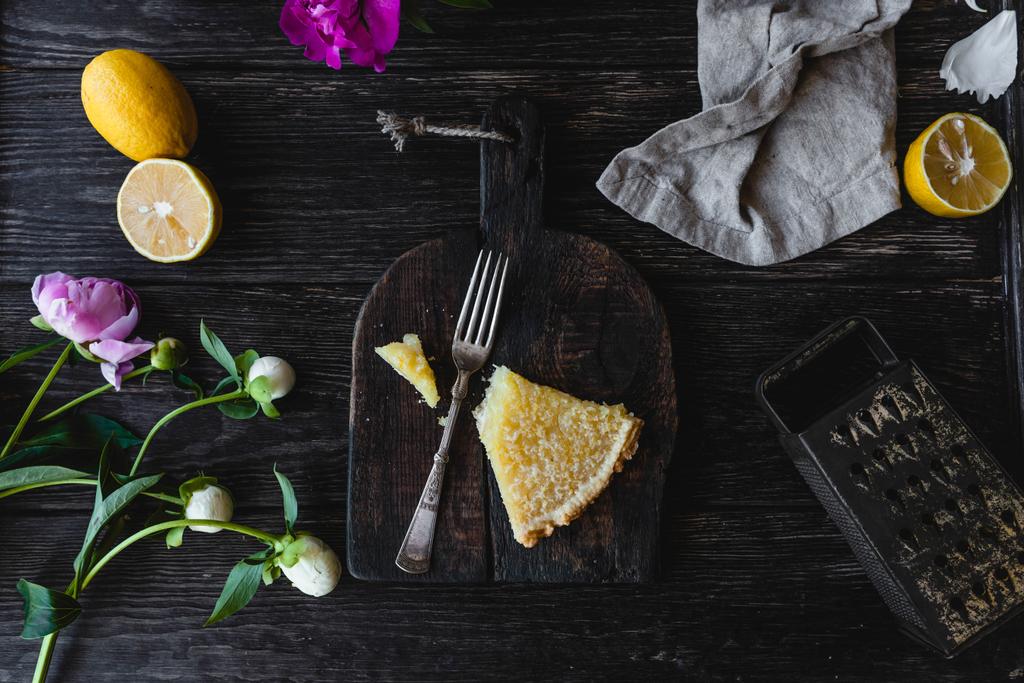 pohled shora kusu chutné citrón koláč a květin na dřevěný stůl - Fotografie, Obrázek