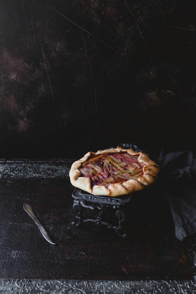 вкусный ревеневый пирог на темном торте стоять на столе
 - Фото, изображение