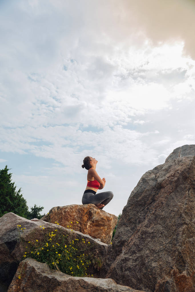 Ciemnowłosa kobieta patrząc w niebo podczas Robienie yoga - Zdjęcie, obraz