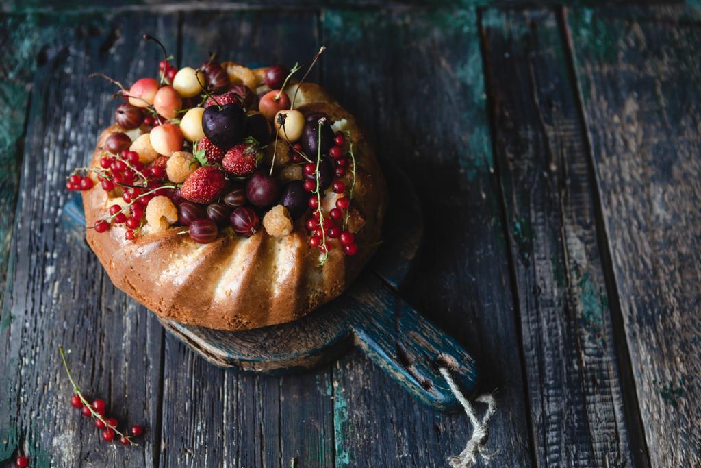 leckerer Kuchen mit Früchten und Beeren auf Schneidebrett - Foto, Bild