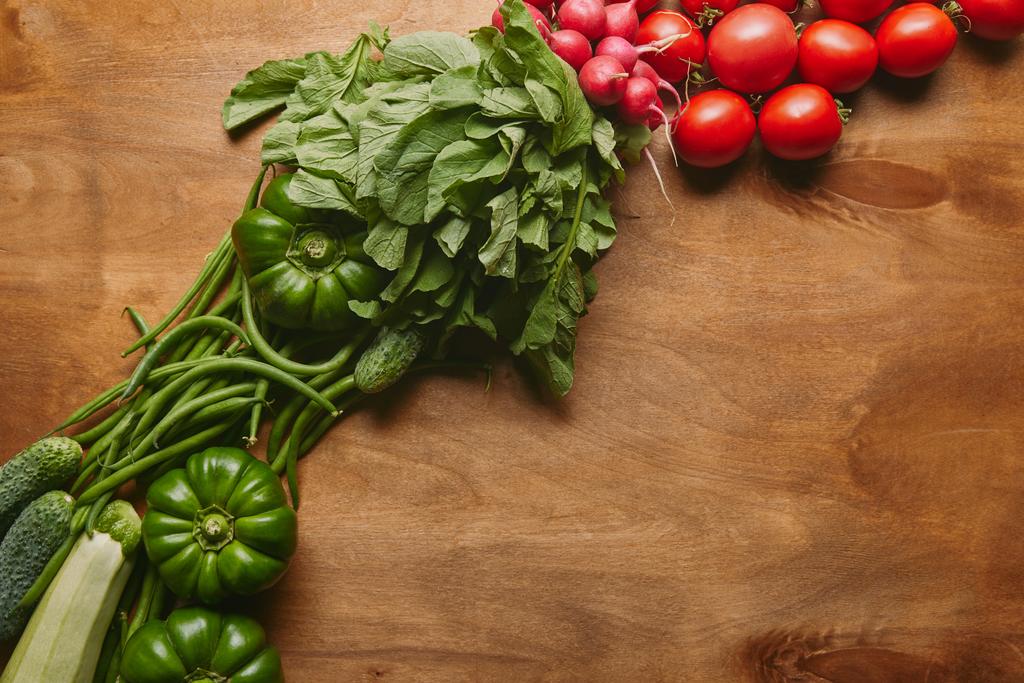 Зелені та червоні літні овочі на дерев'яному столі
 - Фото, зображення