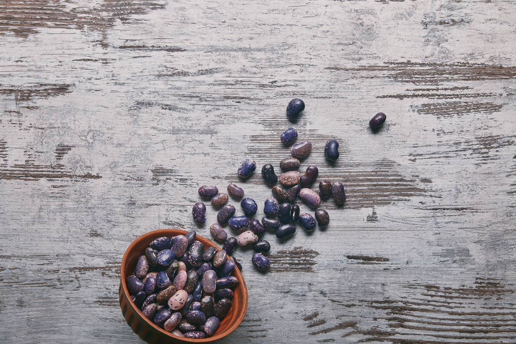 Frijoles haricot secos en tazón sobre mesa de madera rústica
 - Foto, Imagen
