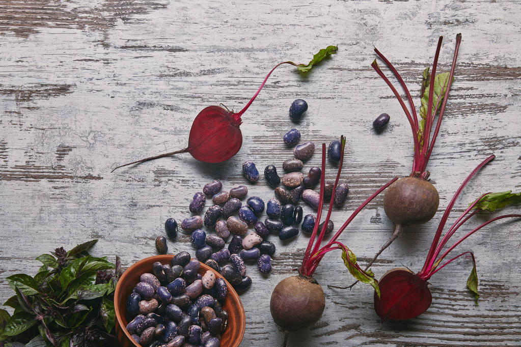 Raw beetroots and haricot beans on rustic wooden table - Photo, Image