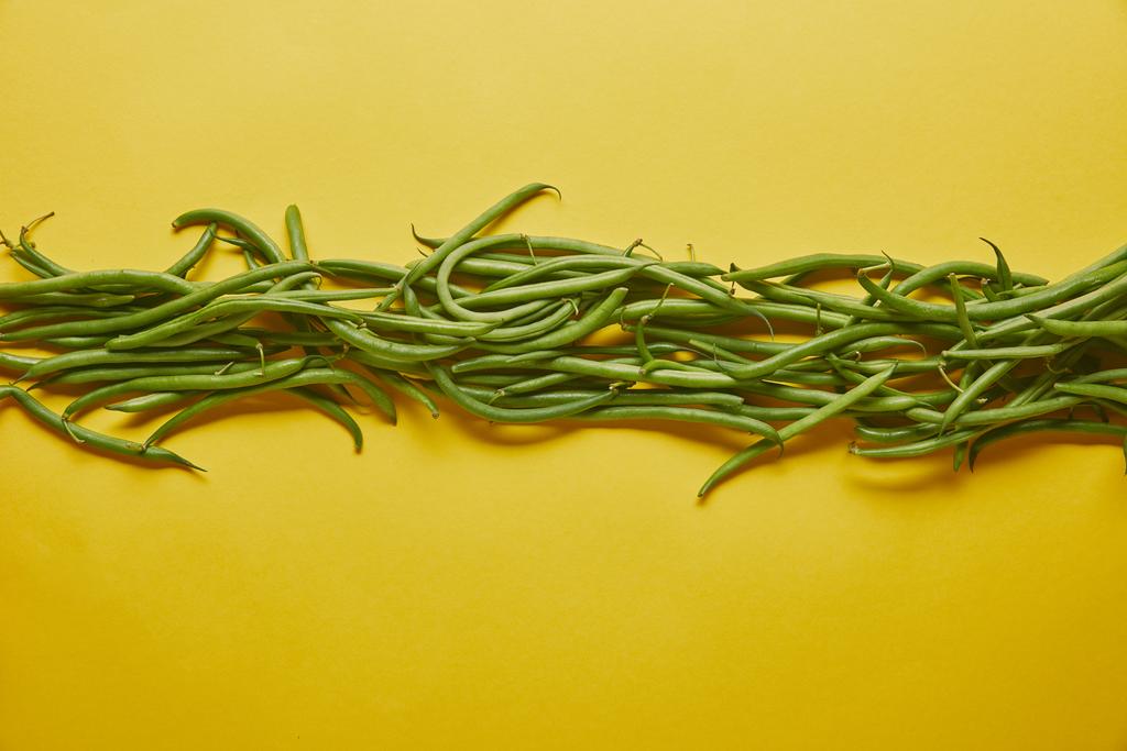 Zelené fazolky v řadě na žlutém podkladu - Fotografie, Obrázek