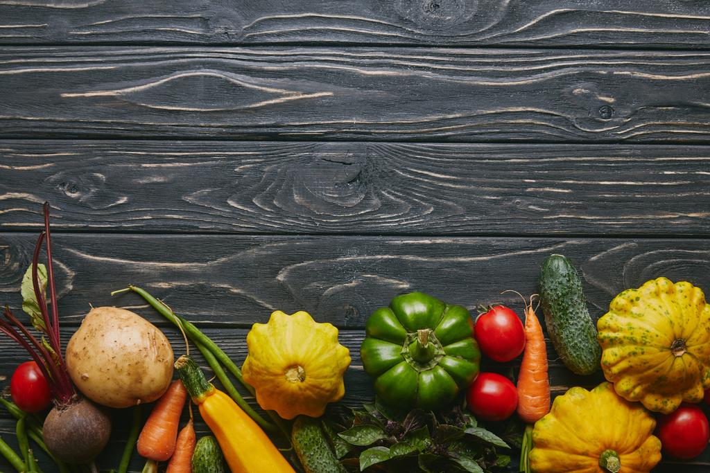 Samenstelling van de levensmiddelen met kleurrijke groenten op donkere houten tafel - Foto, afbeelding