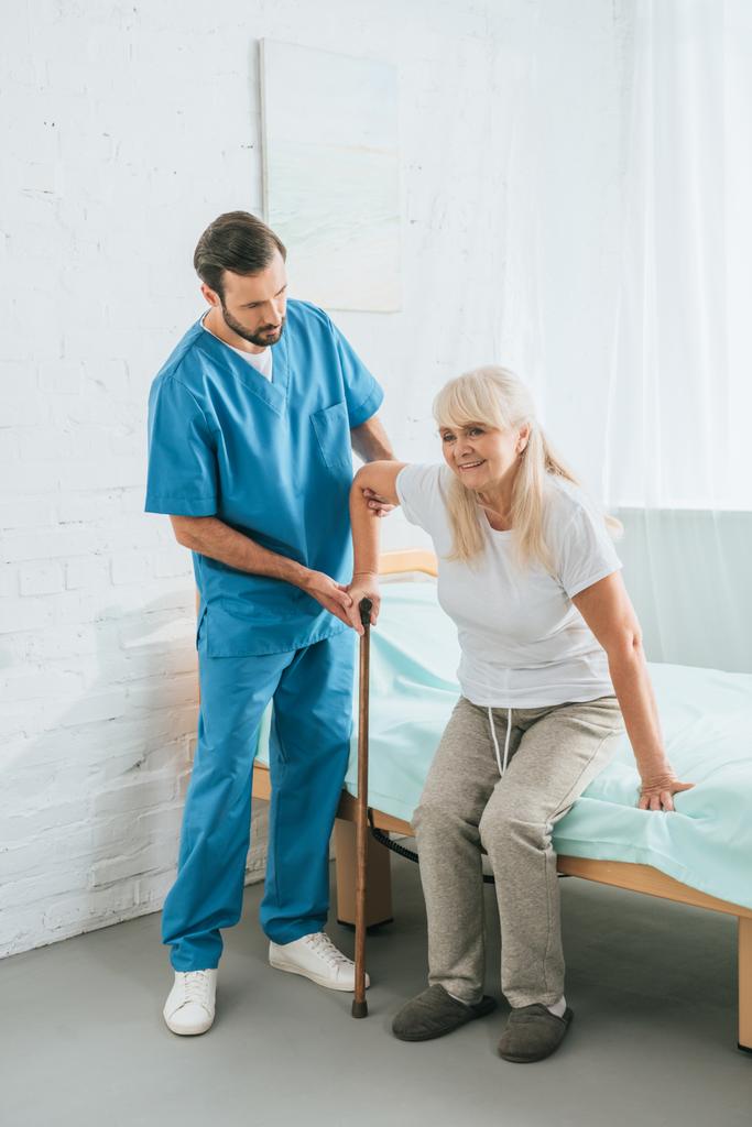 enfermeiro ajudando a mulher idosa com bengala
 - Foto, Imagem
