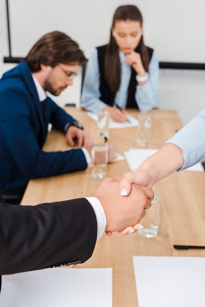 обрізаний знімок ділових людей, які тремтять руками під час зустрічі в сучасному офісі
 - Фото, зображення