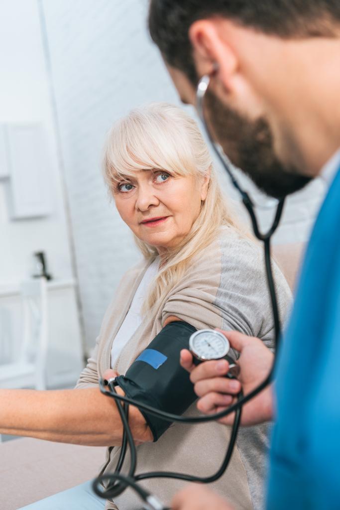 Sozialarbeiterin misst Blutdruck bei Seniorin - Foto, Bild