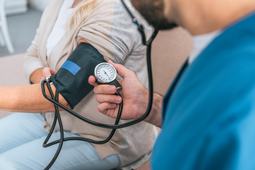 částečné prohlédnout pečovatel měření krevního tlaku a starší žena  - Fotografie, Obrázek