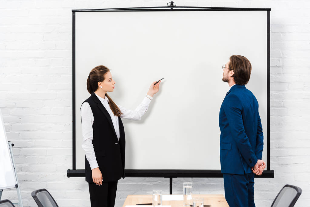 kobieta interesu Dokonywanie prezentacji i wskazując na pustej tablicy w nowoczesnym biurze - Zdjęcie, obraz