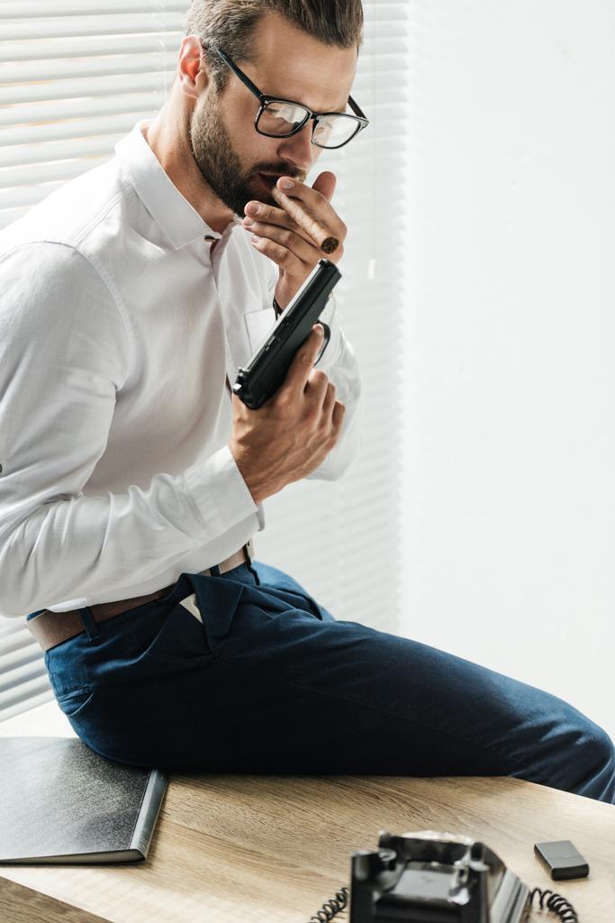 guapo hombre de negocios de moda fumar cigarro con pistola
 - Foto, imagen