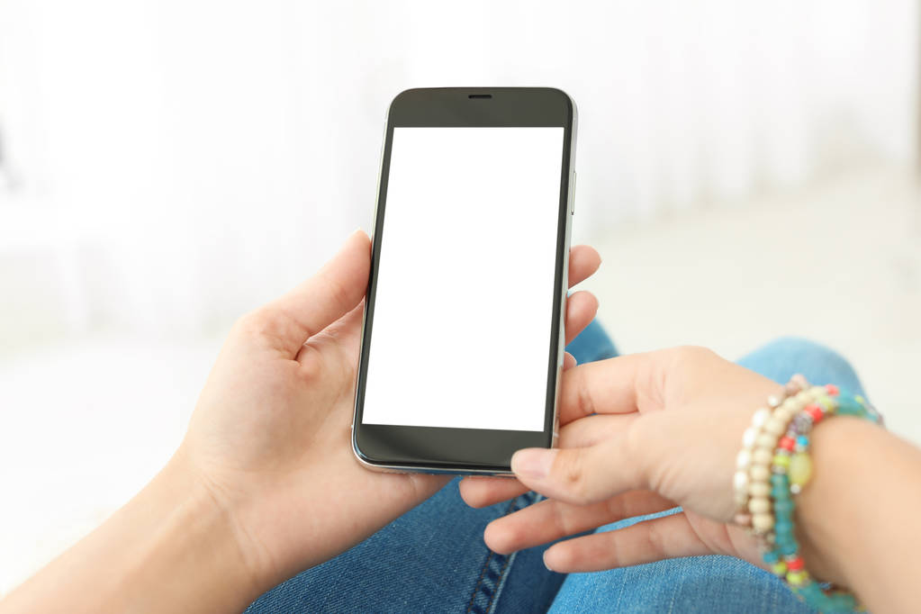 Женщина держит смартфон с пустым экраном на светлом фоне. Макет для дизайна
 - Фото, изображение