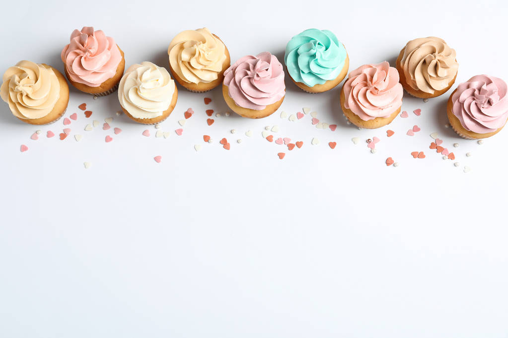 Composição flat lay com deliciosos cupcakes de aniversário e espaço para texto sobre fundo branco
 - Foto, Imagem